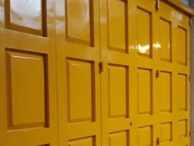 Pintu ganda kuning besar dengan desain panel dalam suasana industri.