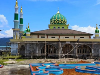 Gerbang masuk suatu bangunan Indonesia dengan elemen arsitektur tradisional dan spanduk penyambutan.